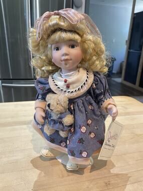 Duck House Heirloom 11 In Doll Abbey Holding A Bear Wearing An Apple Print Dress